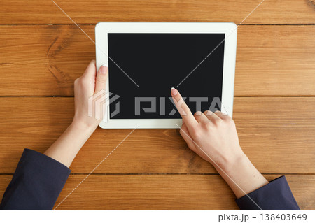 Female using digital tablet. Freelancer working with portable computer, copy space on display, top view, close up 138403649