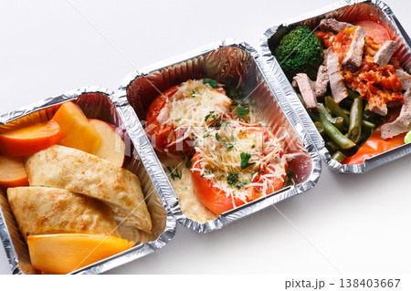 Healthy food in lunch boxes on white background. Eating right concept. Fresh diet daily meals delivery. Vegetables, meat and fruits on wood Healthy food in lunch boxes on white background. Eating right concept. Fresh diet daily meals delivery. Vegetables, meat and fruits on wood 138403667
