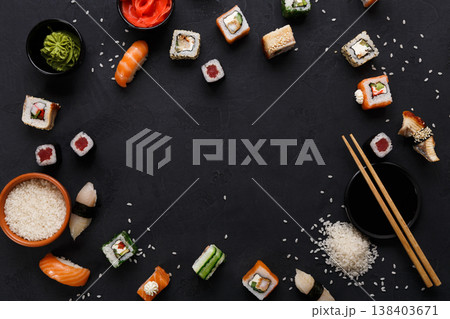 Sushi and rolls background, frame on black, top view. Colorful japanese restaurant food set Sushi and rolls background, frame on black, top view. Colorful japanese restaurant food set 138403671