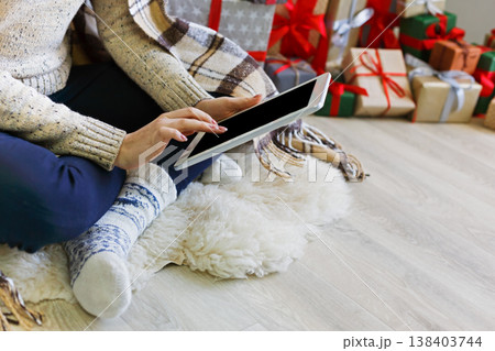 Christmas online shopping. Unrecognized woman buy presents on tablet, prepare to xmas, among gift boxes and packages. Winter sales 138403744