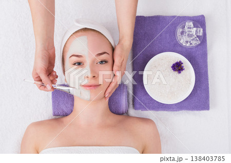 Face mask apply, spa beauty treatment, skincare. Woman getting facial care by beautician at spa salon, top view Face mask apply, spa beauty treatment, skincare. Woman getting facial care by beautician at spa salon, top view 138403785