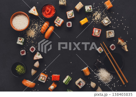 Sushi and rolls background, frame on black, top view, copy space. Colorful japanese restaurant food set Sushi and rolls background, frame on black, top view, copy space. Colorful japanese restaurant food set 138403835