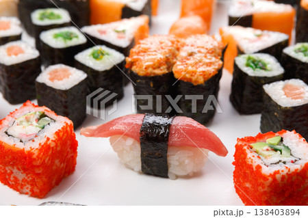 Traditional japanese food delivery. Closeup of sushi set with rolls, gunkan and nigiri at white background Traditional japanese food delivery. Closeup of sushi set with rolls, gunkan and nigiri at white background 138403894