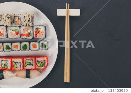 Japanese food restaurant, california salmon rolls and sushi platter. Set with chopsticks and soy sauce. Top view on black background 138403930