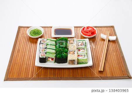 Japanese food restaurant delivery - sushi maki, unagi and roll platter set on mat isolated on white background Japanese food restaurant delivery - sushi maki, unagi and roll platter set on mat isolated on white background 138403965