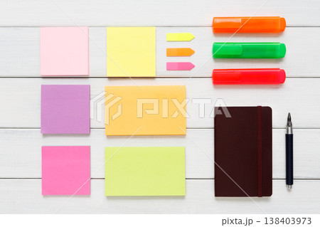 Flat lay of office and business stationery supplies - colorful markers, sticky notes and memo blocks, notepad, pen on white rustic wooden board background, top view with copy space, nobody, objects Flat lay of office and business stationery supplies - colorful markers, sticky notes and memo blocks, notepad, pen on white rustic wooden board background, top view with copy space, nobody, objects 138403973