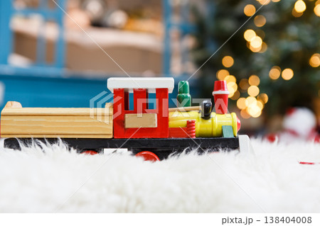 Wooden toy train on snowy decorated background. Selective focus, copy space 138404008