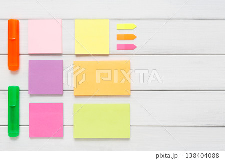 Flat lay of office stationery supplies - colorful markers, sticky notes and memo blocks, notepad on white rustic wood background, top view with copy space, nobody, objects 138404088