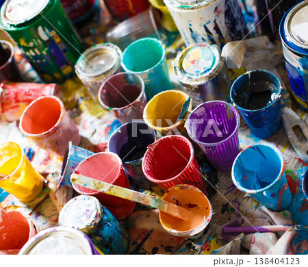 Multicolored plastic cans with paints. Artist workplace background. Old dirty Paints background. Colorful artist palette. Soft toned. Creativity, visual art concept. Art and craft. 138404123
