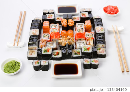 Sushi delivery. Set of rolls, unagi, gunkan served with chopsticks, soy sauce, ginger, wasabi on white background. Japanese dinner for two, pov 138404160