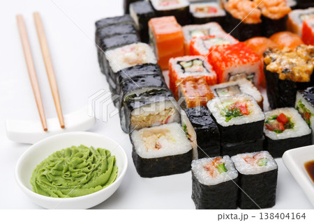 Japanese food restaurant. Sushi set on white background with wasabi bowl and chopsticks, closeup Japanese food restaurant. Sushi set on white background with wasabi bowl and chopsticks, closeup 138404164
