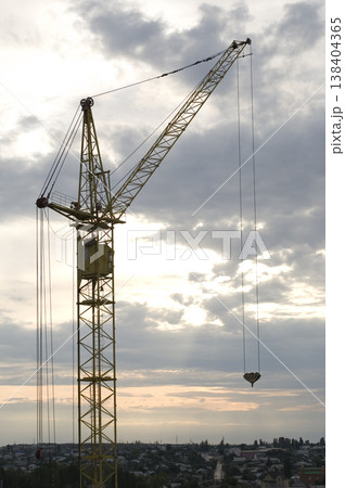 Industrial construction cranes and building silhouettes over sun at sunrise 138404365