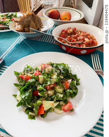 A healthy breakfast is prepared with a quinoa salad made of fresh vegetables and a baked turkey wing placed on a table. Other dishes and fruits are also present, creating a complete meal A healthy breakfast is prepared with a quinoa salad made of fresh vegetables and a baked turkey wing placed on a table. Other dishes and fruits are also present, creating a complete meal 138404478