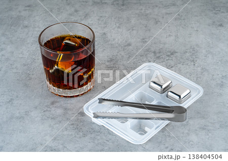 Close-up of a glass containing an alcoholic beverage and metal cooling cubes Close-up of a glass containing an alcoholic beverage and metal cooling cubes 138404504