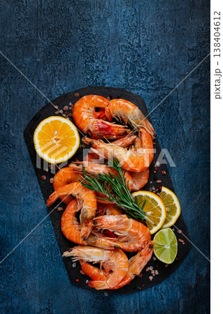 Freshly frozen shrimp, with lemon and rosemary, on black slate, close-up, top view, no people Freshly frozen shrimp, with lemon and rosemary, on black slate, close-up, top view, no people 138404612