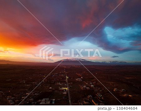 Dramatic sky at sunset over distant mountains and town Dramatic sky at sunset over distant mountains and town 138404684