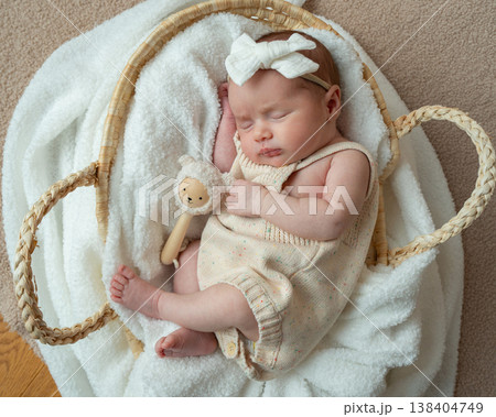Full body portrait of sleeping newborn baby in woven basket. Soft neutral tones and peaceful atmosphere. Concept of safety, care, protection and early parenthood. 138404749