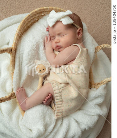 Full body portrait of sleeping newborn baby in woven basket. Soft neutral tones and peaceful atmosphere. Concept of safety, care, protection and early parenthood. 138404750