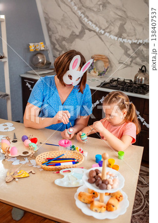 Caucasian mother and daughter creating handmade Easter eggs, focusing on traditions and meaningful family time. Concept of heritage, bonding, love, childhood and holiday preparation. Caucasian mother and daughter creating handmade Easter eggs, focusing on traditions and meaningful family time. Concept of heritage, bonding, love, childhood and holiday preparation. 138407537