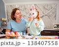 Happy Caucasian mom and little girl creating handmade Easter decorations in a cozy home interior, seasonal celebration, warm family lifestyle, creativity, bonding and love. 138407558