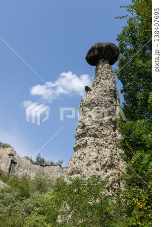 Monumental hoodoo at the Pyramids of Zone near Lake Iseo rises with a heavy boulder Monumental hoodoo at the Pyramids of Zone near Lake Iseo rises with a heavy boulder 138407695