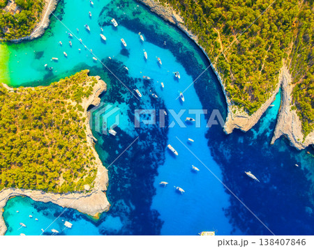 Top down aerial drone view of luxury yachts and boats in a turquoise bay with crystal clear water. 138407846