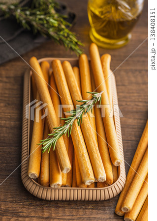 Crunchy Italian Breadsticks (Grissini) With Fresh Rosemary and Olive Oil on Rustic Tray Crunchy Italian Breadsticks (Grissini) With Fresh Rosemary and Olive Oil on Rustic Tray 138408151