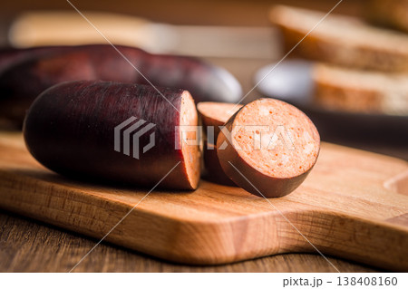 Sliced Blood Sausage on Wooden Cutting Board With Bread in Rustic Kitchen Setting Sliced Blood Sausage on Wooden Cutting Board With Bread in Rustic Kitchen Setting 138408160