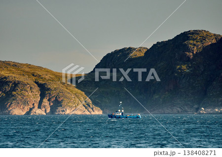 the coast of the Barents Sea, pleasure boats in the sea, the rocky shore with colourful arctic carpet of moss, yagel, Tundra at autumn the coast of the Barents Sea, pleasure boats in the sea, the rocky shore with colourful arctic carpet of moss, yagel, Tundra at autumn 138408271