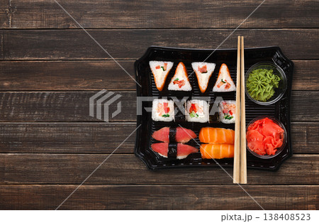 Japanese food delivery. Sushi and rolls top view with copy space on brown wood Japanese food delivery. Sushi and rolls top view with copy space on brown wood 138408523