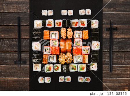 Japanese food restaurant delivery - sushi maki, unagi, gunkan and roll big party platter set on brown wood background, above view Japanese food restaurant delivery - sushi maki, unagi, gunkan and roll big party platter set on brown wood background, above view 138408536