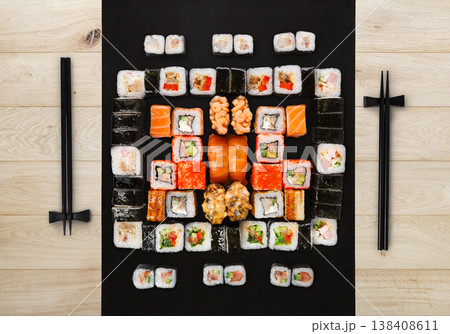 Japanese food restaurant delivery - sushi maki, unagi, gunkan and roll big party platter set on natural wood background, above view Japanese food restaurant delivery - sushi maki, unagi, gunkan and roll big party platter set on natural wood background, above view 138408611