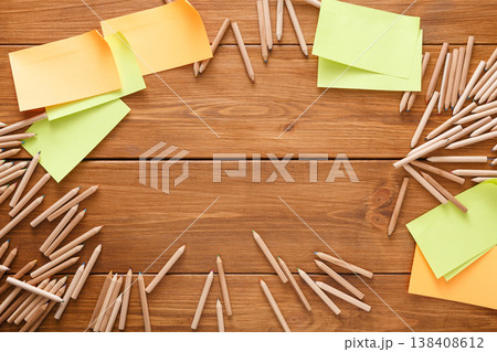 Stationery - top view of blank yellow sticky and memo notes and color pencils making frame with copy space on wooden table background, nobody, objects Stationery - top view of blank yellow sticky and memo notes and color pencils making frame with copy space on wooden table background, nobody, objects 138408612