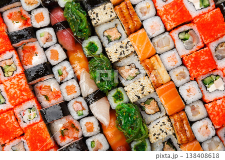 Sushi and rolls pattern background, japanese restaurant delivery top view. Salmon, unagi, california and other healthy meals Sushi and rolls pattern background, japanese restaurant delivery top view. Salmon, unagi, california and other healthy meals 138408618