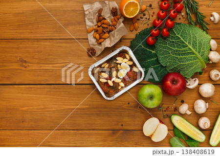 Healthy food delivery background. Lunch box with eggs and almonds on rustic wood table, copy space 138408619