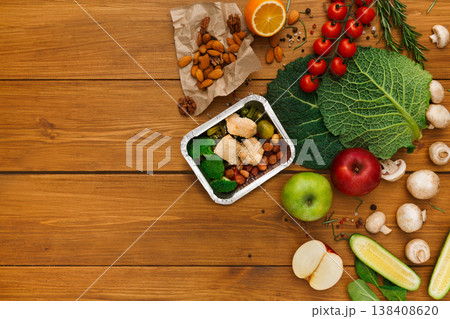 Healthy food delivery background. Lunch box with broccoli, chicken and hazelnuts on rustic wood table, copy space 138408620