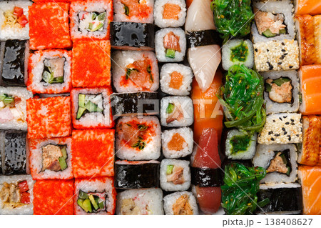 Sushi and rolls pattern background, japanese restaurant delivery top view. Salmon, unagi, california and other healthy meals Sushi and rolls pattern background, japanese restaurant delivery top view. Salmon, unagi, california and other healthy meals 138408627