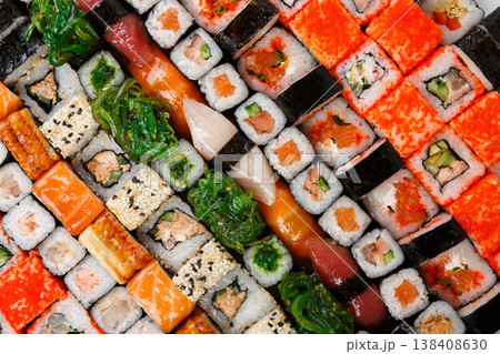 Sushi and rolls pattern background, japanese restaurant delivery top view. Salmon, unagi, california and other healthy meals Sushi and rolls pattern background, japanese restaurant delivery top view. Salmon, unagi, california and other healthy meals 138408630