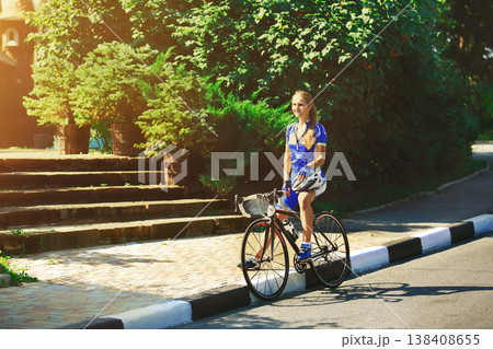 Break, stop at road. Woman cycling on countryside summer road or highway. Triathlon or cycling competition. 138408655