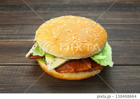 Classic american burger fast food. Big double burger at wood. Hamburger with fresh vegetables and meat. Burger with cheese, beef, tomato, lettuce. Cheeseburger at rustic wooden background. 138408664