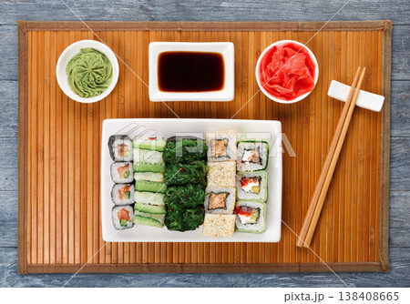 Japanese food restaurant delivery - sushi maki, unagi and roll platter set on mat on blue wood background, above view 138408665