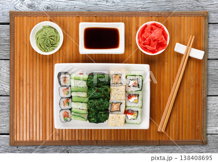 Japanese food restaurant delivery - sushi maki, unagi and roll platter set on mat on gray wood background, above view Japanese food restaurant delivery - sushi maki, unagi and roll platter set on mat on gray wood background, above view 138408695