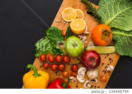 Cooking healthy vegetarian food background. Frame of fresh organic vegetables on black with copy space. Natural food and wooden cutting board Cooking healthy vegetarian food background. Frame of fresh organic vegetables on black with copy space. Natural food and wooden cutting board 138408794