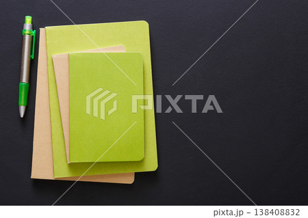 Stylish mockup with set of green notebooks and pen on black background with copy space, flat lay, concept of start-up and stationery supplies Stylish mockup with set of green notebooks and pen on black background with copy space, flat lay, concept of start-up and stationery supplies 138408832