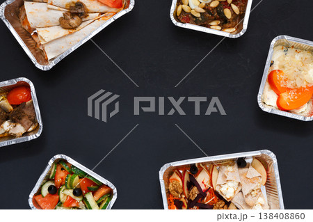 Healthy restaurant food delivery background with copy space. Mockup for menu, foil containers with meals on black Healthy restaurant food delivery background with copy space. Mockup for menu, foil containers with meals on black 138408860