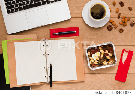 Healthy food delivery. Lunch box with diet meal on workplace, flat lay of wooden desktop with foiled container Healthy food delivery. Lunch box with diet meal on workplace, flat lay of wooden desktop with foiled container 138408878