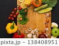 Cooking healthy vegetarian food background. Frame of fresh organic vegetables on black. Natural food and wooden cutting board with copy space. 138408951