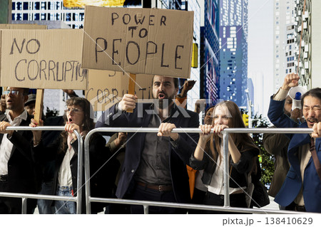 Activists marching together in political protest against corruption and misconduct, raising banners and signs to demand justice and reform. Dissatisfaction and public awareness in a rally. 138410629