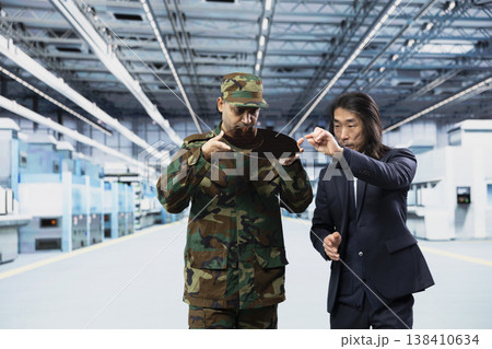 Evaluating microchip development, RD and Indian soldier with microelectronics facility manager. Doing manufacturing plant tour, silicon wafers and army defense contractor with senior professional 138410634