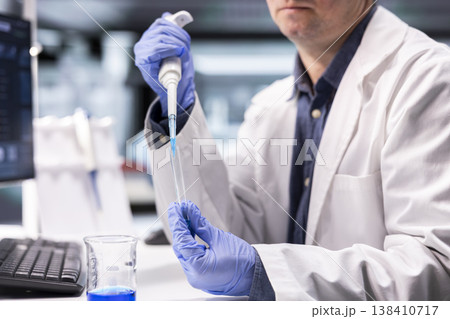 Researcher in chemistry lab uses pipette and jar to mix bio samples. Experiment with compound preparation demonstrate precision in science and molecular biology for innovation, biolab. 138410717